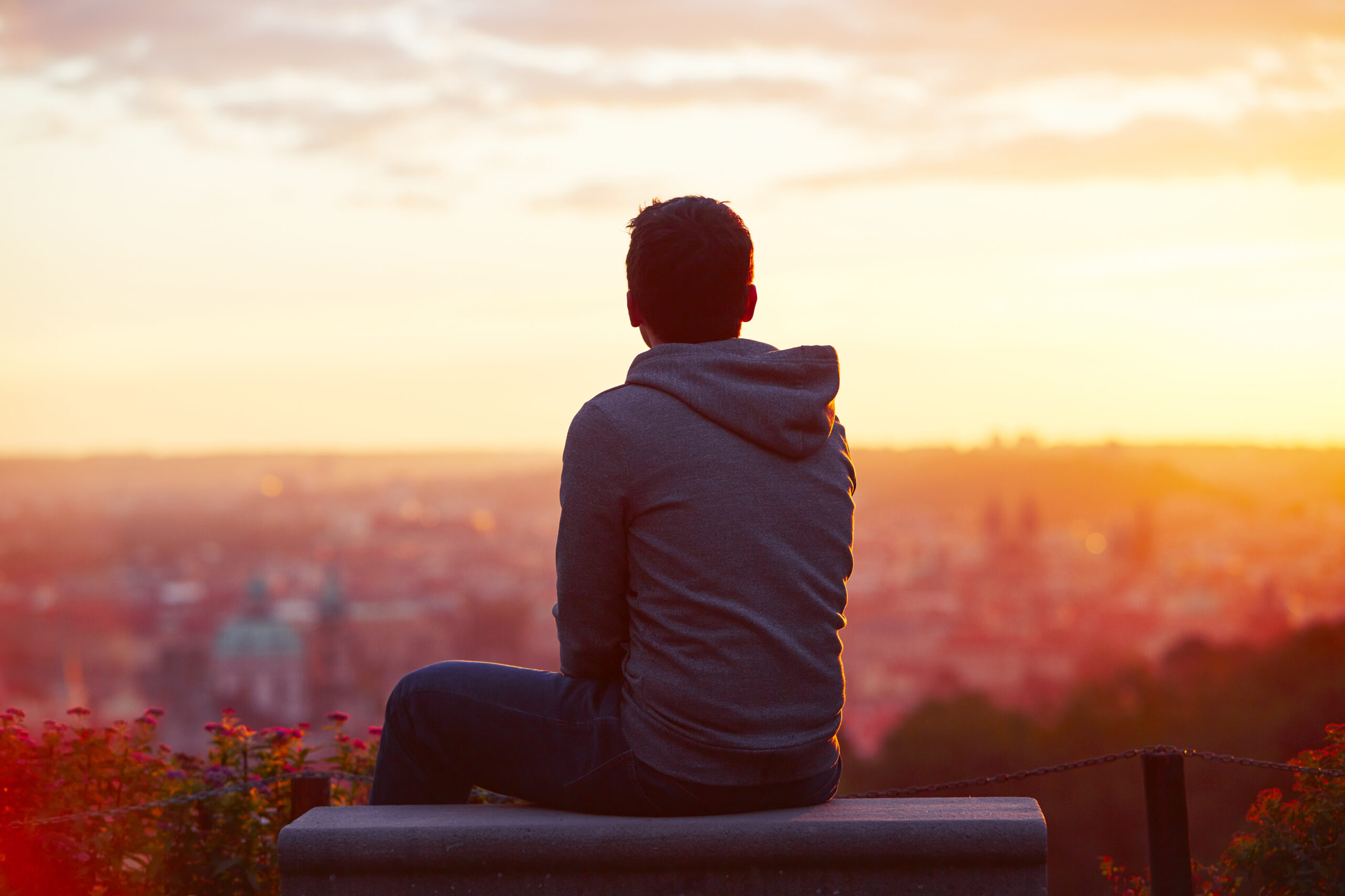 Young man is looking at the sunrise.